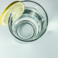 a glass of water with lemon on it