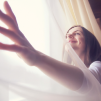 A woman wakes up, opens curtains, sunlight fills the room, she stretches with a relieved smile. Soft cinematic movement, warm tones.