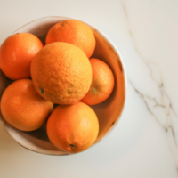 a bowl of oranges with fresh bright coloours