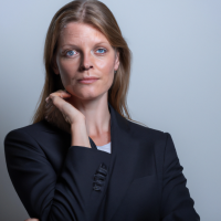 A square portrait professional picture of a 30 year old white female from head to chest dressed in a business suit.