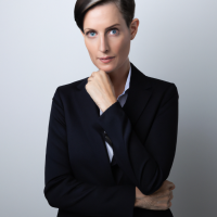 A square portrait professional picture of a 30 year old white female from head to chest dressed in a business suit.