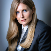 A square portrait professional picture of a 30 year old white female from head to chest dressed in a business suit.
