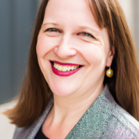A square portrait professional picture of a 30 year old white female dressed in a business suit.
