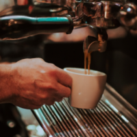 fresh cup of express being brewed by a barrista
